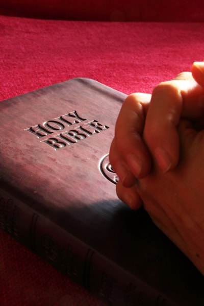Hands clasped on Bible