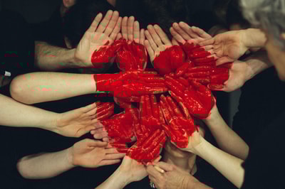 Hands painted red with a heart