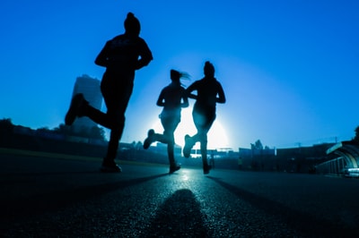 Three people jogging in the dark