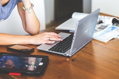 Woman with laptop phone and books