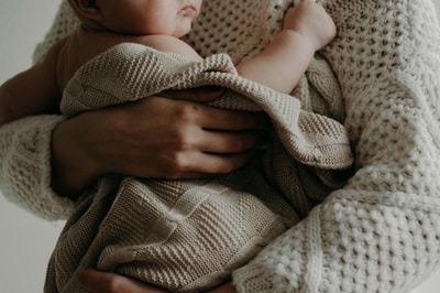A lady holding a baby in a blanket