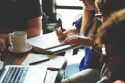 A Group Of People Around A Table And Pc