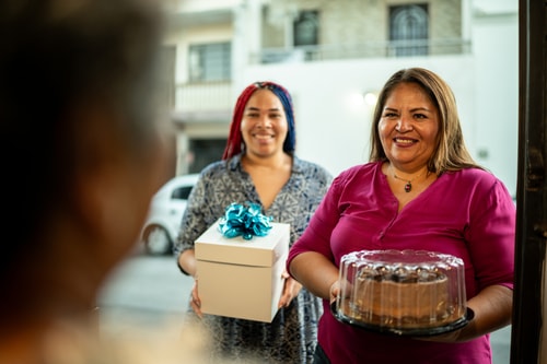 Mother and daughter arrive with cake FG Trade Latin istock