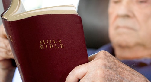 Old man reading Bible blur