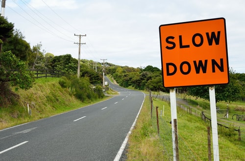 Slow down road sign