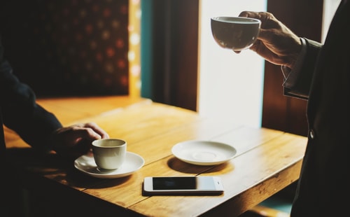 Two Men Drinking Tea At Table