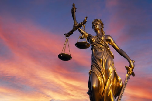 Close up of Lady Justice on a sunset sky background