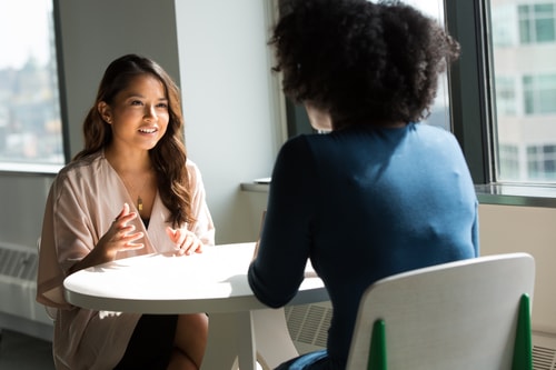 Two women talking over table