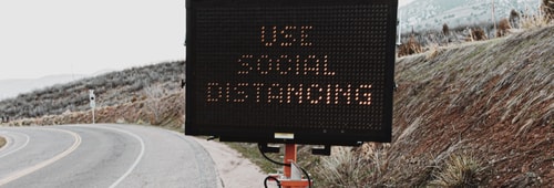 Road sign displaying social distancing