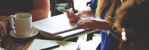 A Group Of People Around A Table And Pc