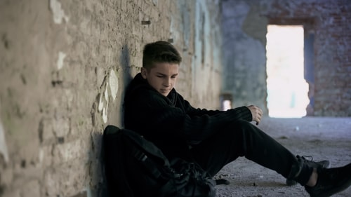 Teenage boy alone in building