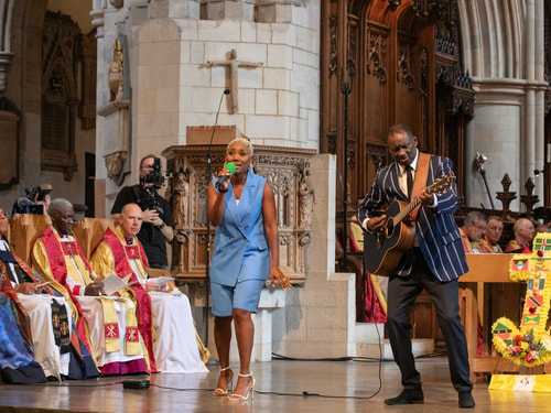 Two artists performing at the Windrush 75 anniversary