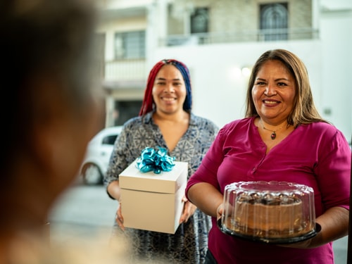 Mother and daughter arrive with cake FG Trade Latin istock
