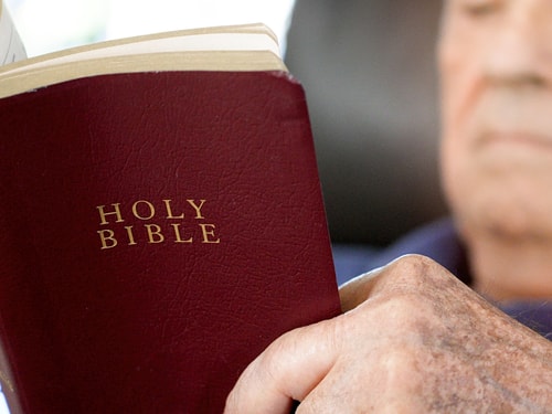 Old man reading Bible blur