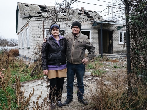 RS15229 Vyacheslav and Olga outside their damaged home 13